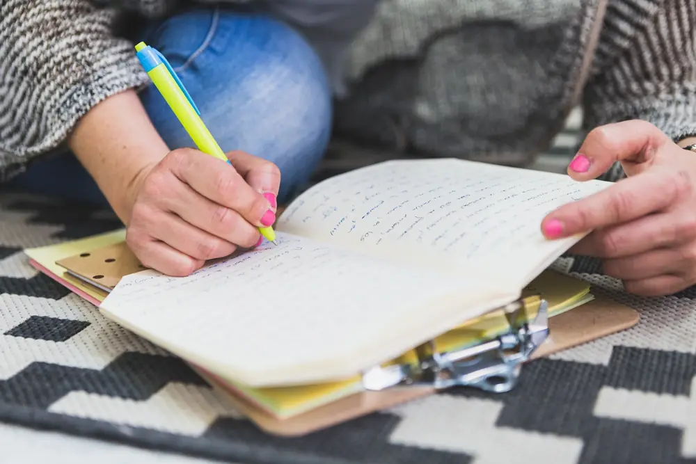 Close up of a person writing in a notebook
